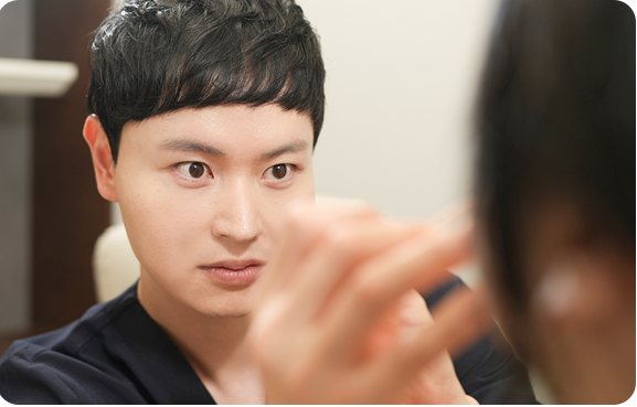 환자 얼굴을 살피며 상담하는 남자 의사