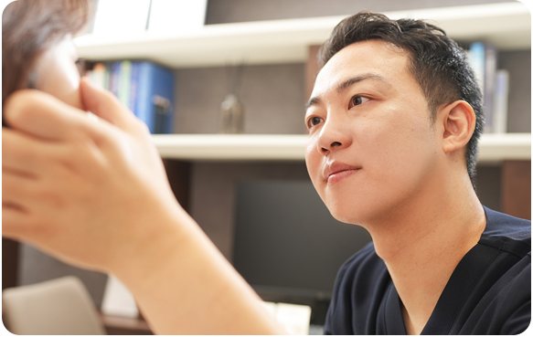 환자 얼굴을 살피는 남자 의사
